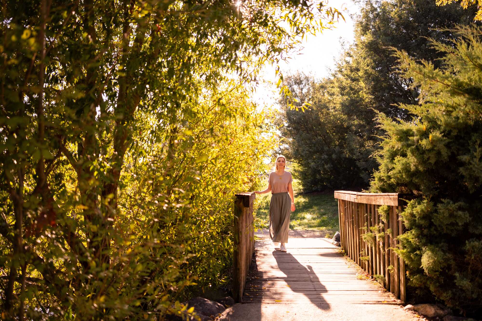 Mélissa Vidal, psychologue en ligne proposant l'EMDR et la walking thérapie à Toulouse, marchant sur un pont en bois pour symboliser l'accompagnement thérapeutique.